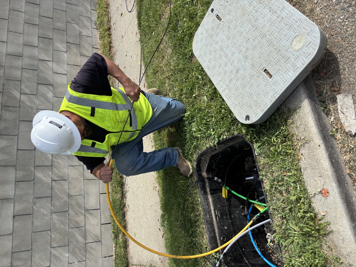 An Aspire Fiber crew member pulling fiber at a street vault
